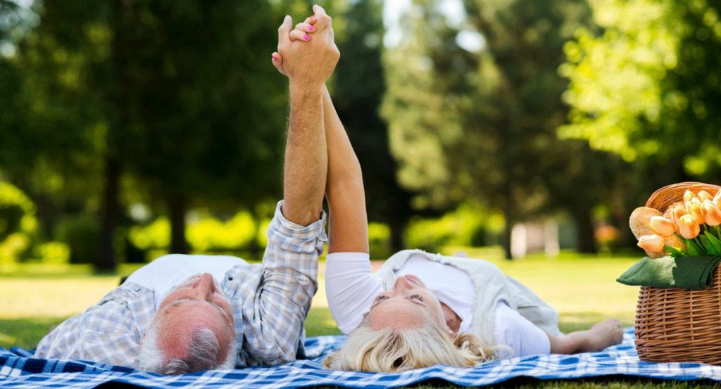 Älteres Paar liegt entspannt auf der Wiese