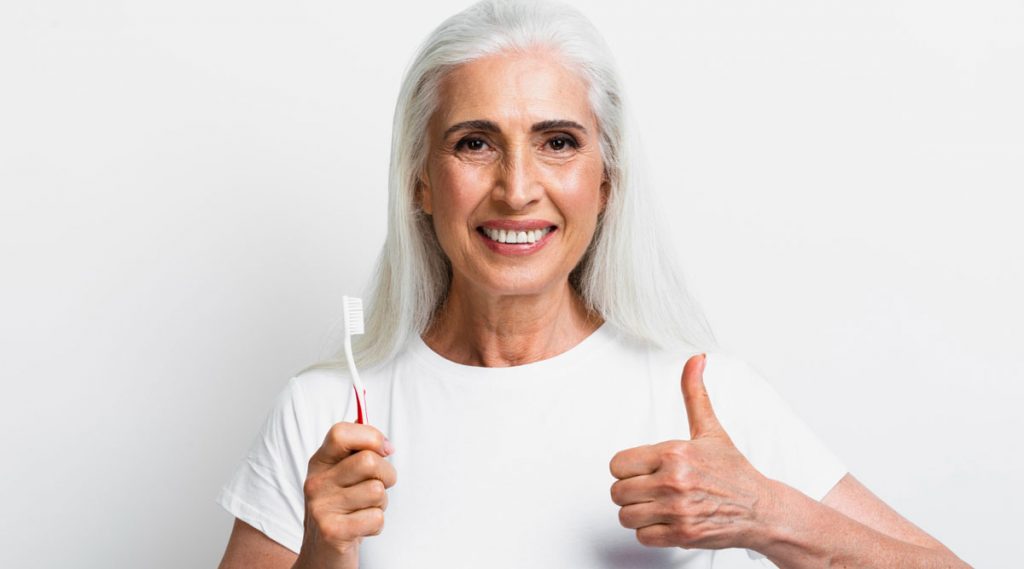 Seniorin bei der Zahnpflege